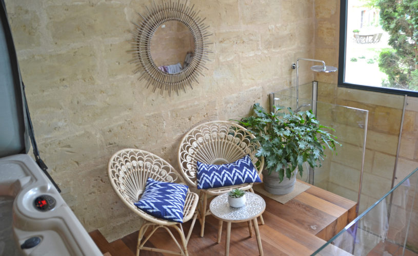 photo détail de la douche du jacuzzi, fauteuil et miroir en osier avec coussins bleus et blancs, chambres d'hôtes château Pont Saint-Martin, Pessac Léognan, Bordeaux