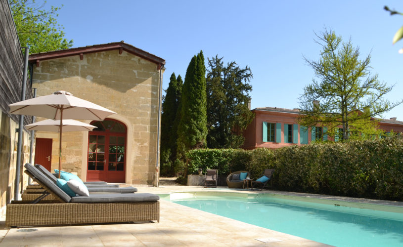 photo de l'extérieur du château avec vue sur la piscine, mise en scène avec fauteuils de piscine