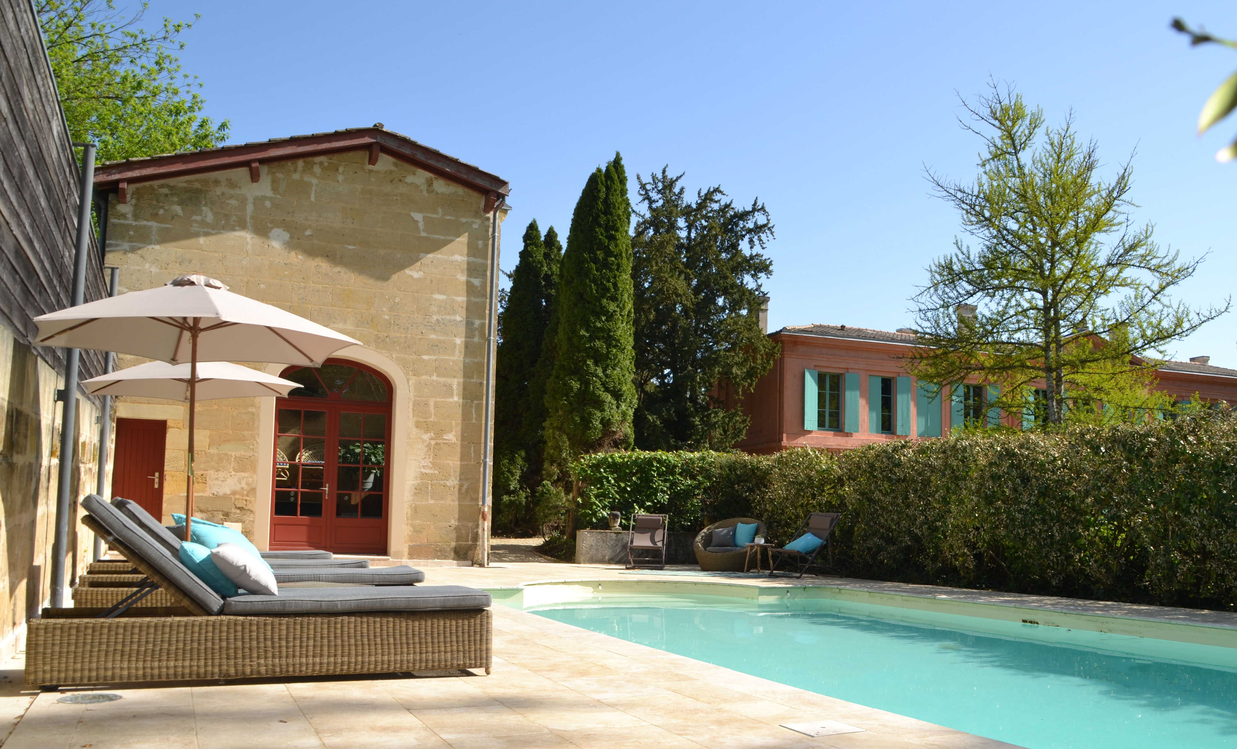 photo de l'extérieur du château avec vue sur la piscine, mise en scène avec fauteuils de piscine